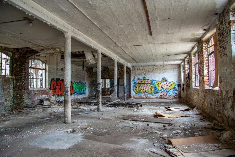 an abandoned building with graffiti on the walls, by Arnie Swekel, pexels contest winner, fan favorite, sprawling, panoramic, debris