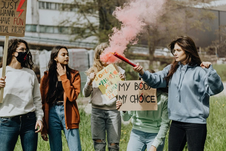 a group of women standing next to each other holding signs, by Emma Andijewska, pexels contest winner, smoke grenade, teenage no, coloured, on a canva