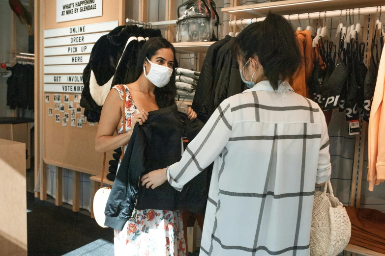 a woman standing next to a woman wearing a face mask, happening, clothing drop, wearing black vest and skirt, people shopping, sara ali