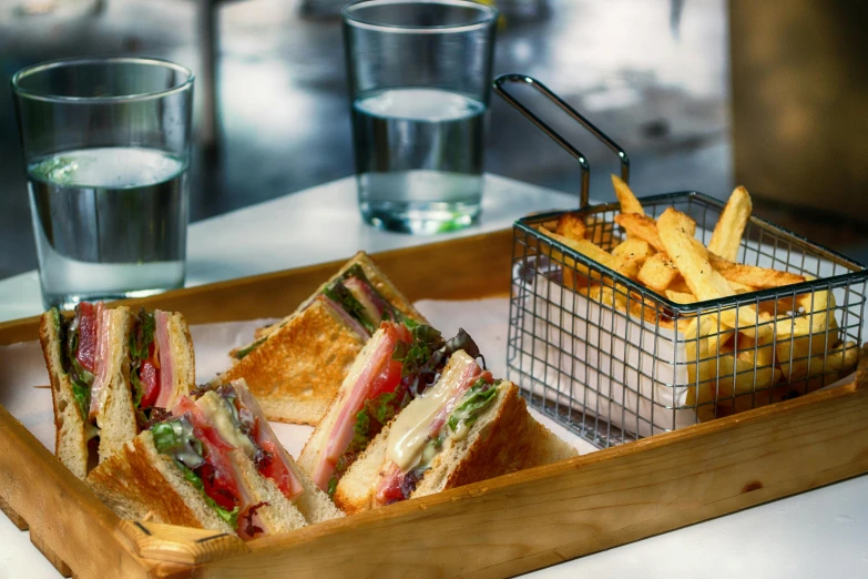 a tray filled with sandwiches and fries next to a glass of water, renaissance, hollywood standard, fan favorite, striped, curated collection