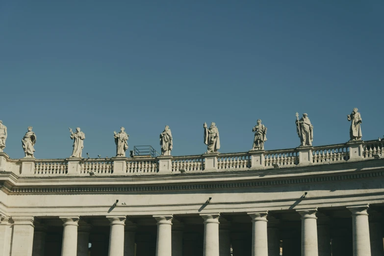 a group of statues sitting on top of a building, by Cagnaccio di San Pietro, pexels contest winner, neoclassicism, colonnade, john paul ii, high resolution image, high quality image”