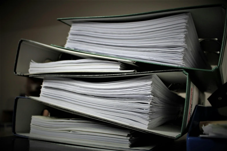 a stack of papers sitting on top of a desk, by Thomas Häfner, paul barson, lossless, seen from below, covered