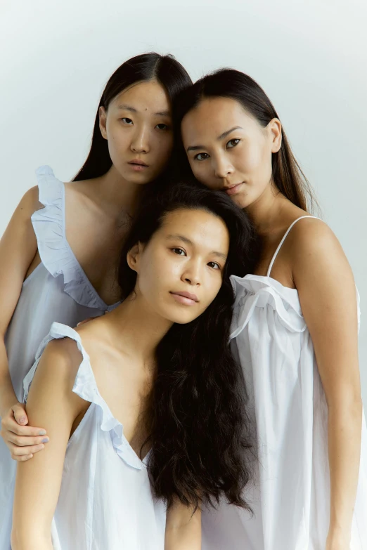 a group of three women standing next to each other, an album cover, inspired by Fei Danxu, unsplash, nightgown, model face, white, half asian