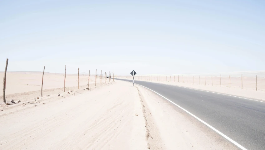 a street sign sitting on the side of a road, by Nathalie Rattner, unsplash contest winner, postminimalism, desert scene, chile, thin straight lines, ignant