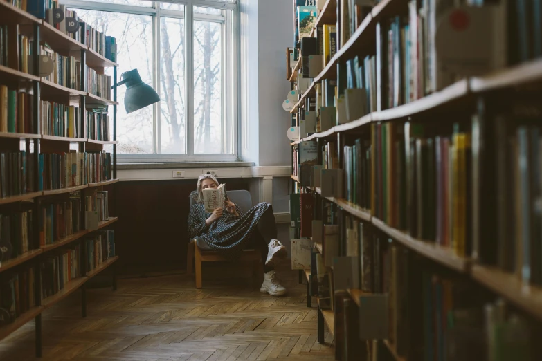 a person reading a book in a library, unsplash contest winner, sitting alone, russian academic, casually dressed, gif