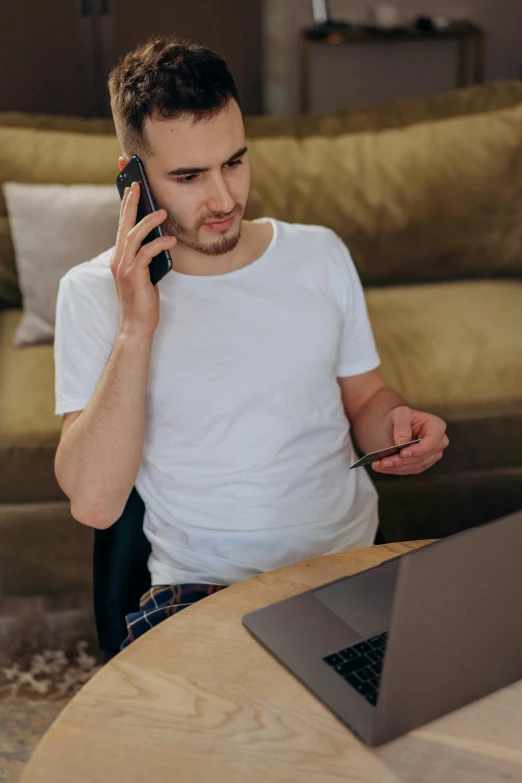 a man sitting at a table talking on a cell phone, laptop, homelander, promo image, large)}]