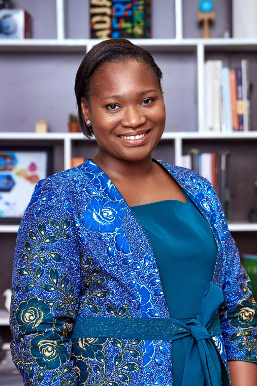 a woman standing in front of a bookshelf, by Chinwe Chukwuogo-Roy, corporate photo, screensaver, brown, top