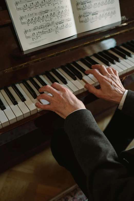 a man in a suit playing a piano, by David Simpson, pexels, still from film, promo image, multiple stories, at home