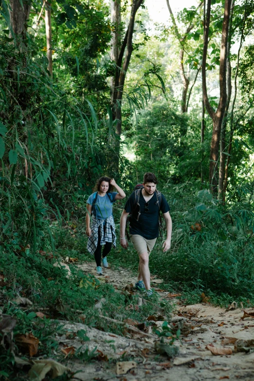 a couple of people that are walking in the woods, unsplash, happening, malaysia jungle, head down, a green, laos