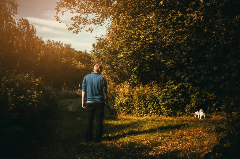 a man walking down a path with a dog, by Eglon van der Neer, pexels contest winner, happening, soft autumn sunlight, in the garden, standing on a hill, older male