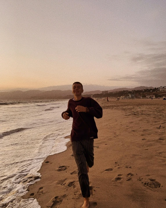 a man running on a beach next to the ocean, an epic non - binary model, teddy fresh, ((sunset)), leaked photo