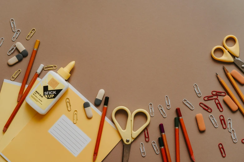 a bunch of office supplies sitting on top of a table, trending on pexels, academic art, brown and gold, background image, drawing for children, opening shot