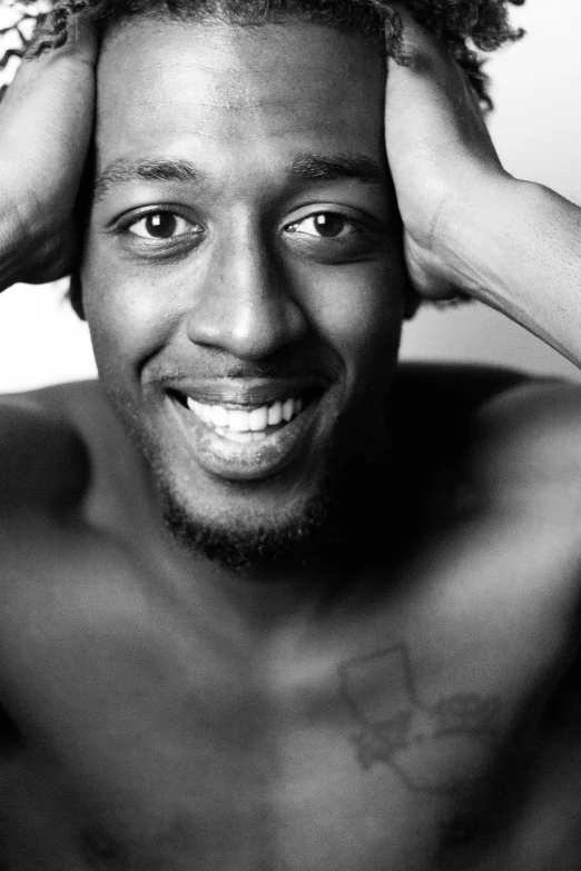 a black and white photo of a man with curly hair, a black and white photo, atiba jefferson, smiling seductively, square, mario testino