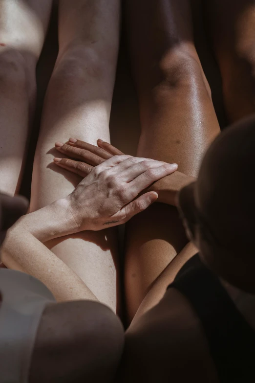 a group of people holding hands in a circle, a tattoo, inspired by Vanessa Beecroft, renaissance, spa, dark warm light, bare thighs, resting head on hands