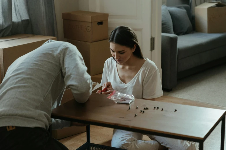 a couple of people that are sitting at a table, broken furniture, on a desk, highly capsuled, leaving a room