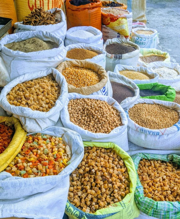 a bunch of bags of food sitting on top of a table, by Carey Morris, pexels, ethiopian, square, gravels around, color photo