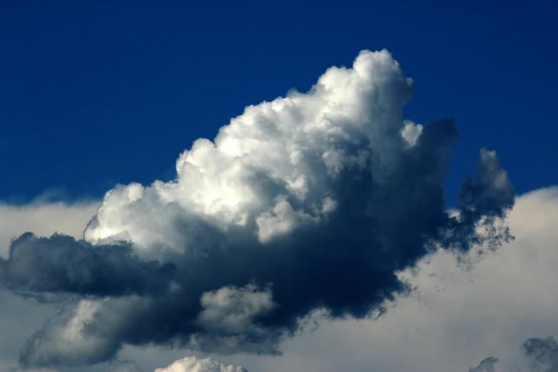 a large cloud in the middle of a blue sky, by Dave Allsop, unsplash, towering cumulonimbus clouds, taken in the late 2010s, looking left, close-up photograph