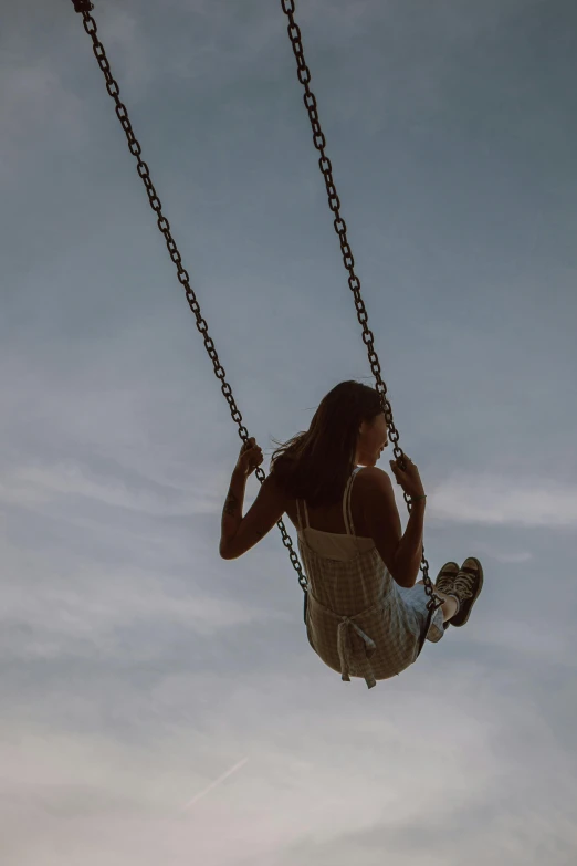 a woman that is sitting on a swing, pearly sky, shot with hasselblade camera, deep aesthetic, profile image