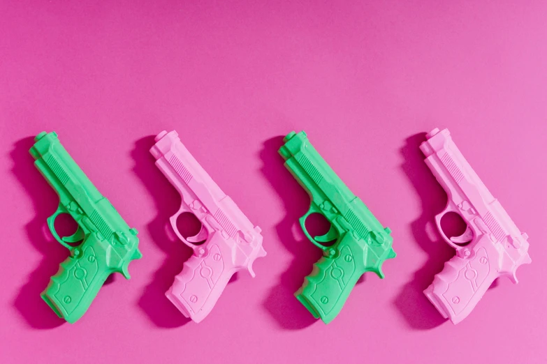 four pink and green toy guns on a pink background, trending on pexels, pop art, homicide, i és complex, 3d printed, backdrop