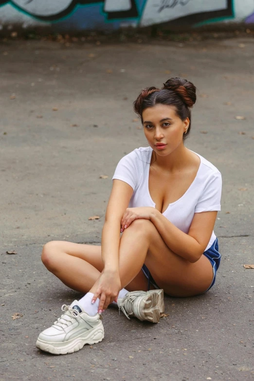 a woman sitting on the ground next to a skateboard, wearing white camisole, 5 0 0 px models, charli xcx, street photo