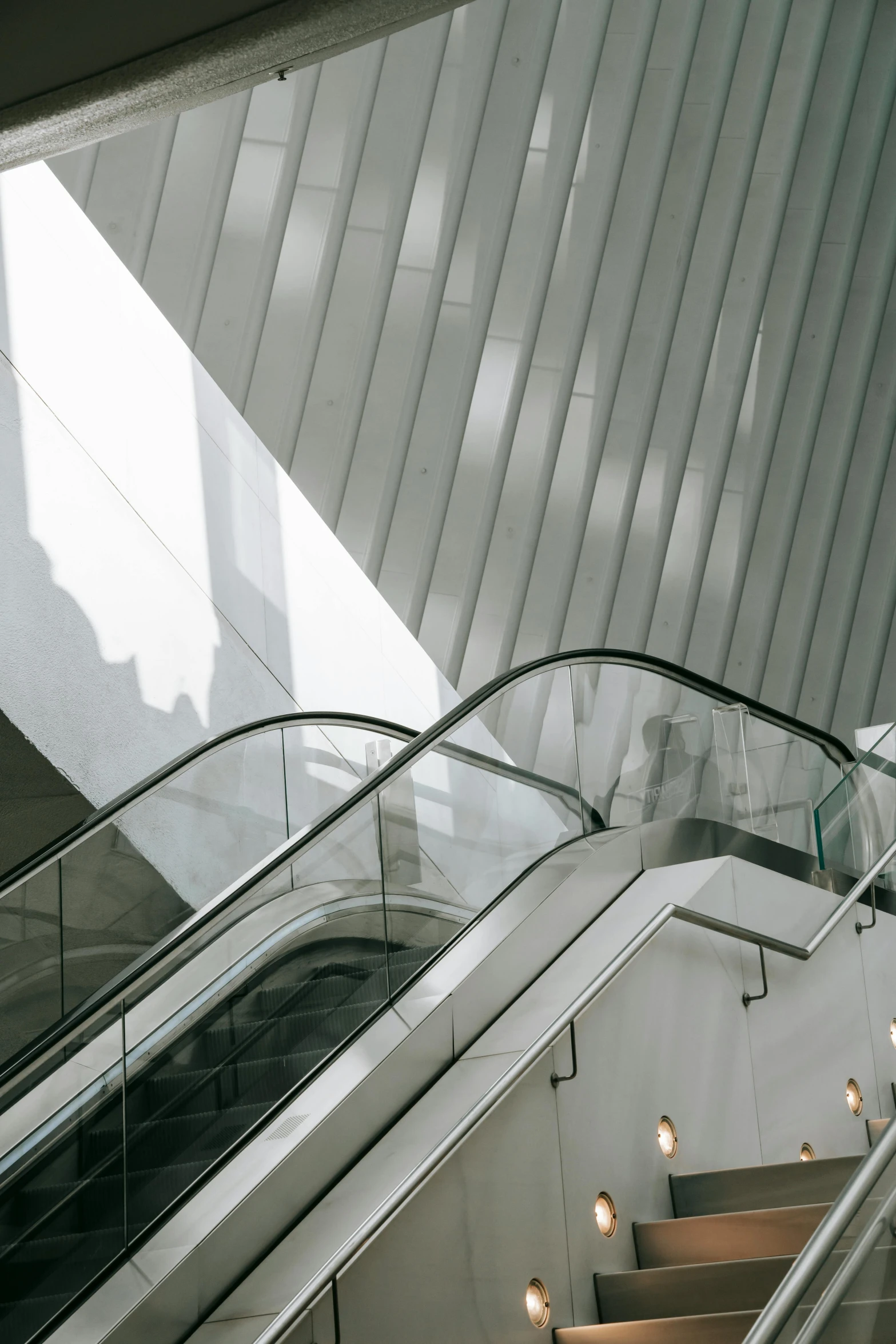 a couple of escalators sitting next to each other, trending on unsplash, light and space, norman foster, santiago calatrava, in new york city, high-quality photo