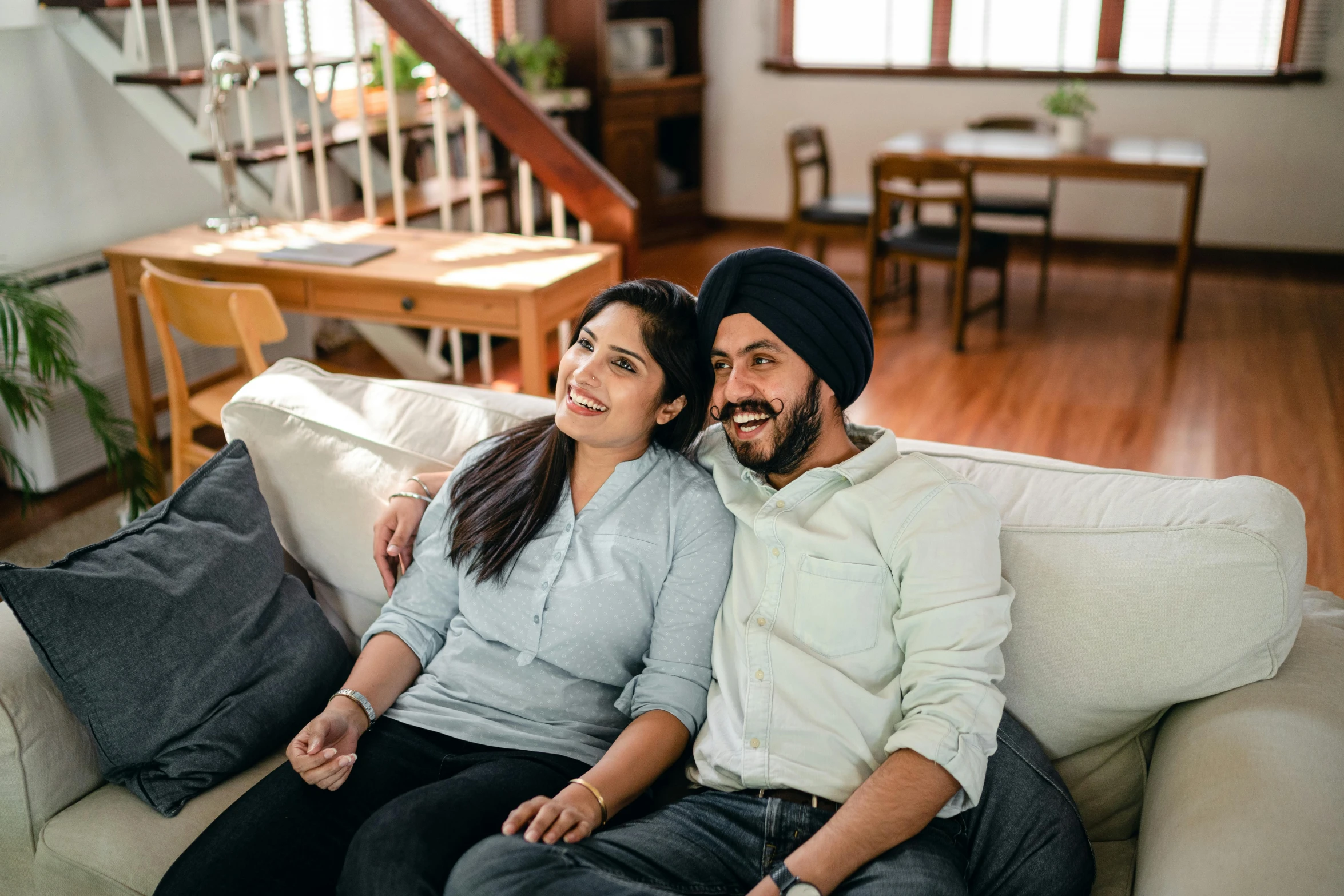 a man and a woman sitting on a couch, inspired by Manjit Bawa, happening, watching tv, in australia, premium quality, product introduction photo