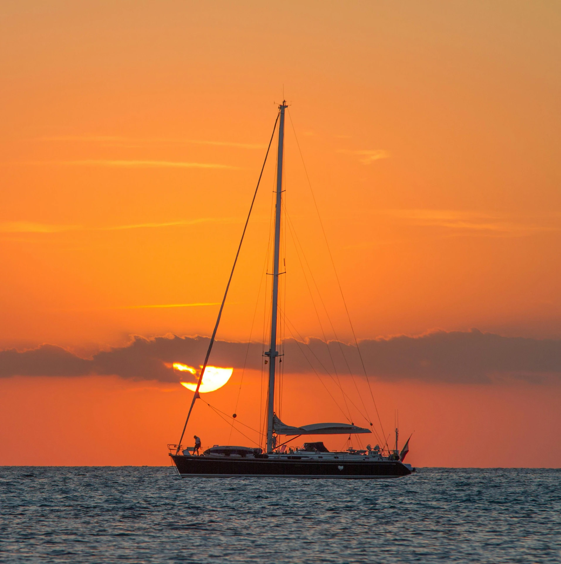 a sailboat in the middle of the ocean at sunset, seraphine, three quarter angle, orange glow, romantic