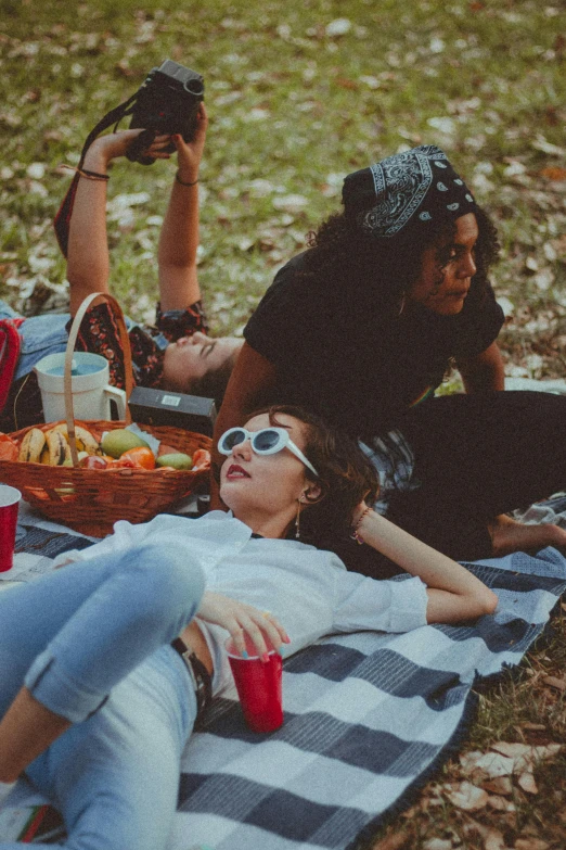 a couple of people laying on top of a blanket, pexels contest winner, people on a picnic, having a cool party, sydney park, dark-skinned