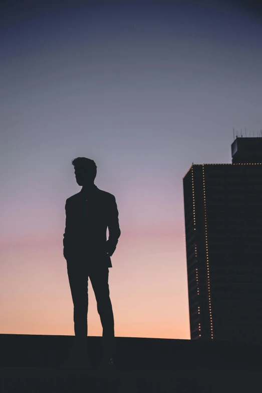 a silhouette of a man standing on top of a building, by Niko Henrichon, pexels contest winner, handsome man, slightly pixelated, carson ellis, tall and lanky skinny