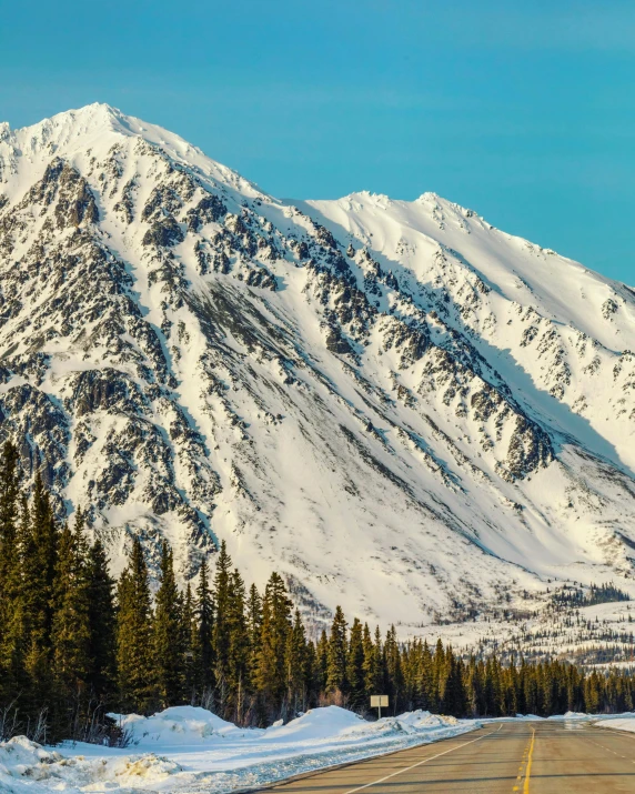 a highway with snow covered mountains in the background, by Julia Pishtar, boreal forest, white marble buildings, campsites, panoramic