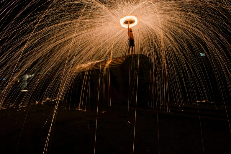 a man standing on top of a building holding an umbrella, a stipple, by Sebastian Spreng, pexels contest winner, luminous fire halo, small people with torches, slow shutter, body made of fire