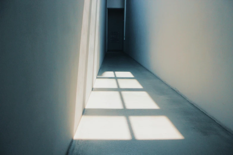 the sun shines through a window in an empty room, inspired by Elsa Bleda, unsplash contest winner, light and space, white concrete floor, shadow cast of dark corridor, volumetric lighting - n 9, instagram picture