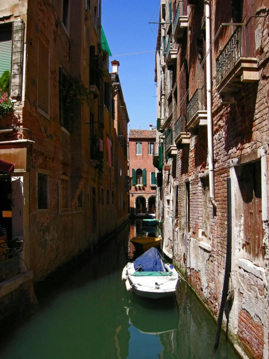 a small boat is docked in a narrow canal, a photo, by Canaletto, pexels contest winner, renaissance, great light and shadows”, 2 0 0 4 photograph, a quaint, marker”