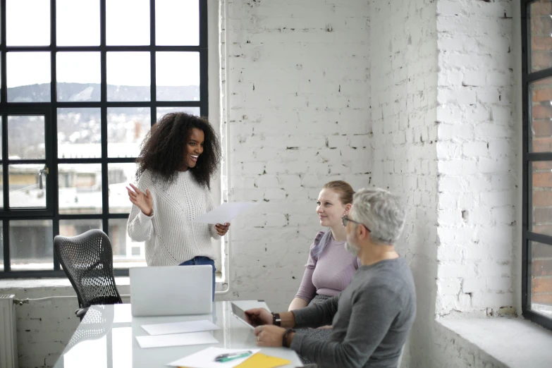 a group of people sitting around a table with laptops, by Carey Morris, pexels contest winner, wearing business casual dress, giving a speech, white backround, woman holding another woman