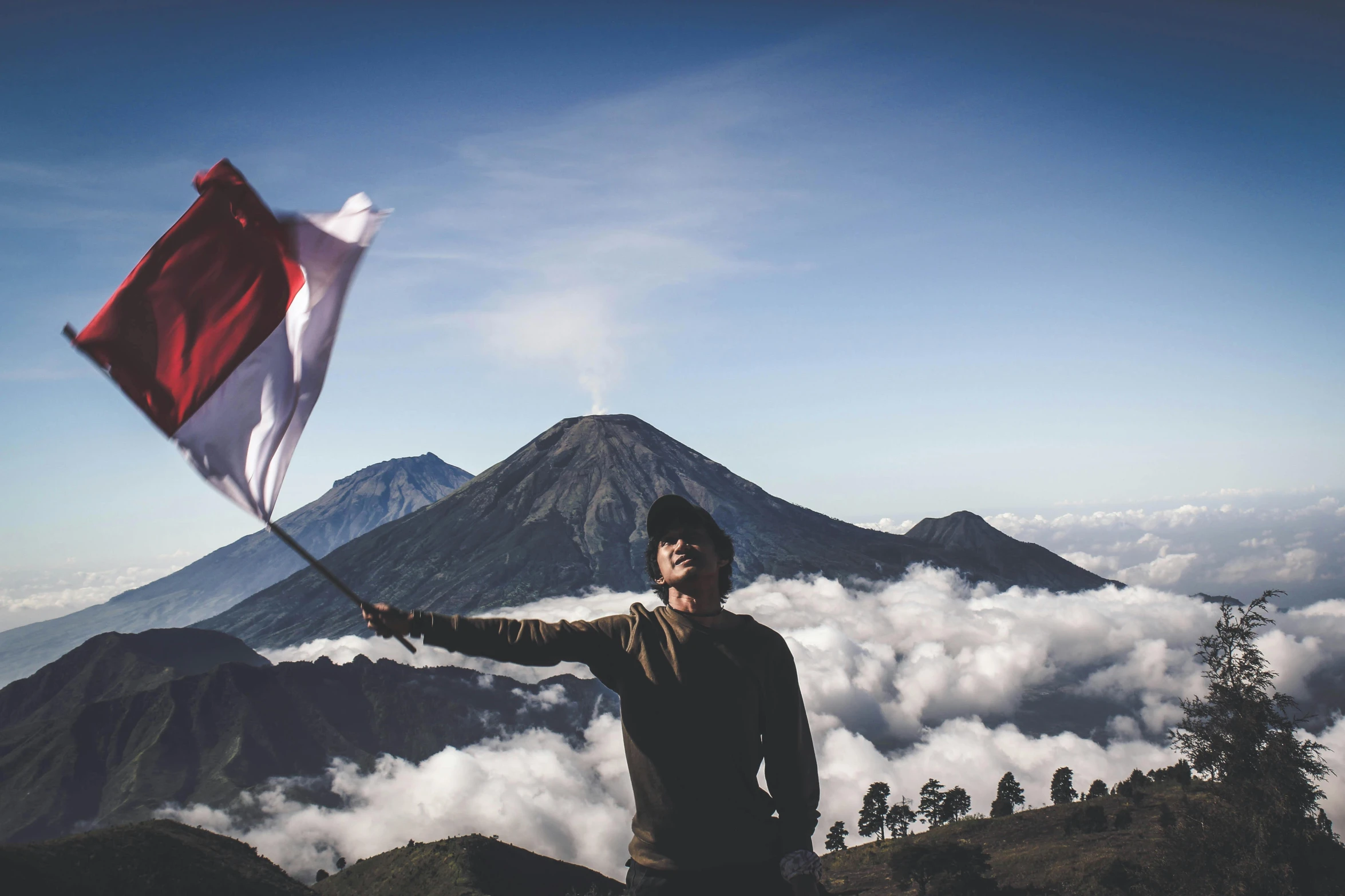 a man holding a flag on top of a mountain, by Julia Pishtar, pexels contest winner, sumatraism, background image, portrait of apex legends, 🚿🗝📝, grey