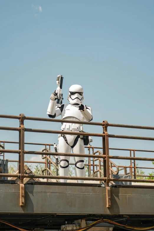 a couple of people that are standing on a bridge, a statue, inspired by George Lucas, happening, female stormtrooper, disney studios, slide show, laser beam ; outdoor