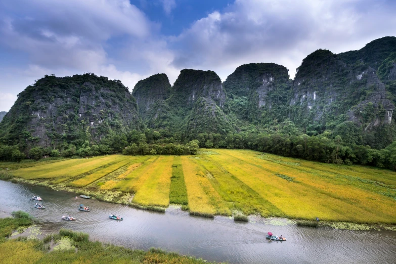 a river running through a lush green field, by Reuben Tam, pexels contest winner, boats in the water, ao dai, floating mountains, concert