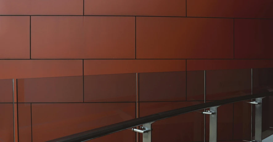 a close up of a railing near a building, a digital rendering, inspired by Bauhaus, bauhaus, gradient dark red, coper cladding, glazed ceramic, wood panel walls