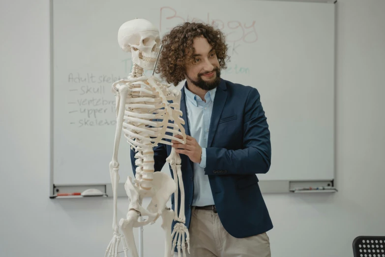 a man standing in front of a model of a skeleton, a cartoon, by Adam Marczyński, pexels contest winner, academic art, sitting in the classroom, sam hyde, sebastien chabal, medium head to shoulder shot