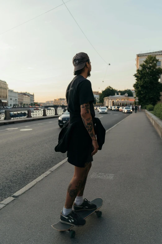 a man riding a skateboard down the side of a road, by Alexander Runciman, pexels contest winner, saint petersburg, wearing black shorts, photograph of a sleeve tattoo, looking smug
