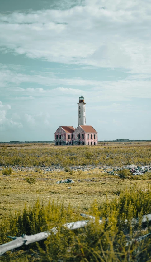 a light house sitting on top of a lush green field, by Carey Morris, pexels contest winner, aruba, wes anderson film, square, panoramic