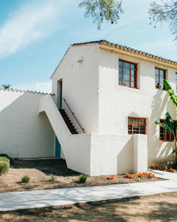 a white house sitting on the side of a road, by Carey Morris, unsplash, renaissance, rammed earth courtyard, the city of santa barbara, color corrected, apartment