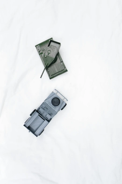 a couple of cassettes laying on top of a bed, by Sam Havadtoy, military equipment, high angle security camera feed, tank, plastic toy