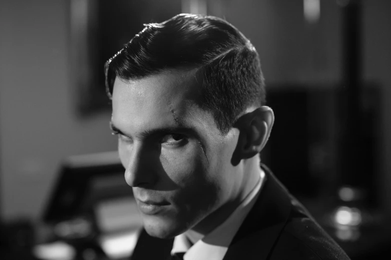 a black and white photo of a man in a suit, inspired by Yousuf Karsh, young jim caviezel, alan turing, vampire, still from a terence malik film