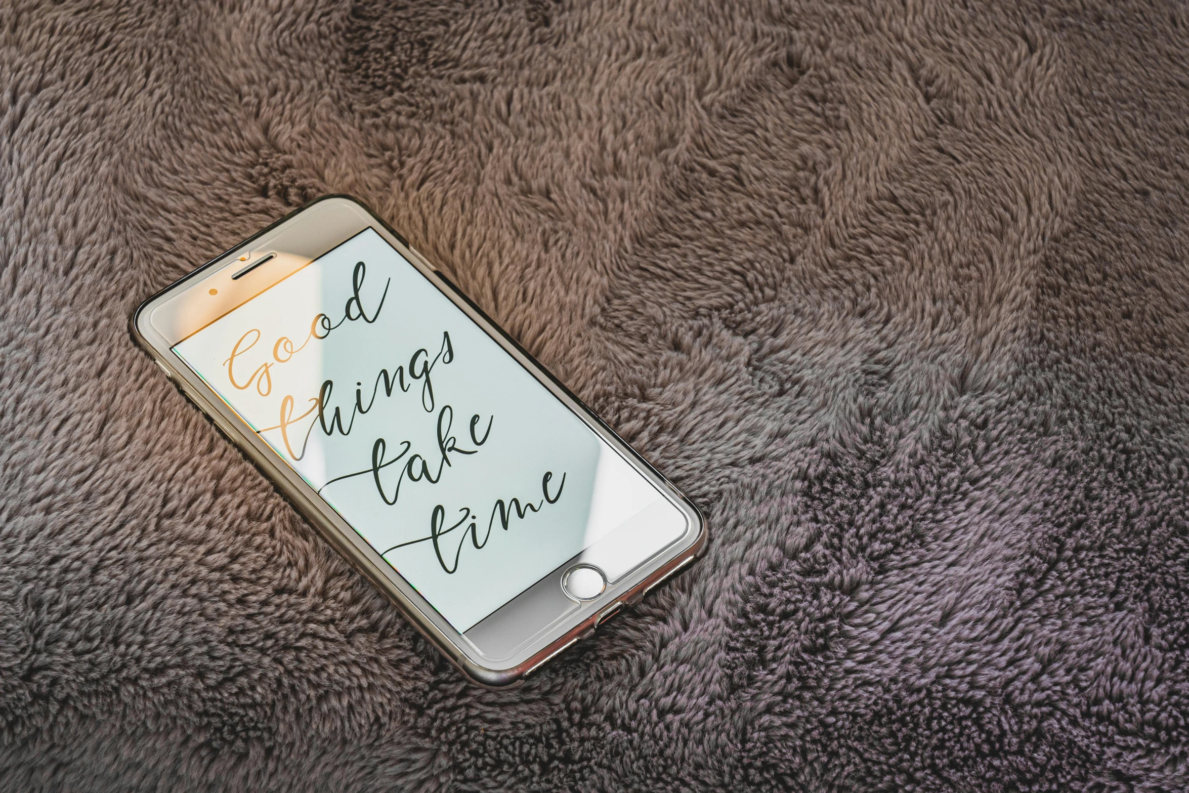 a cell phone sitting on top of a brown blanket, a digital painting, by Robbie Trevino, trending on pexels, happening, lettering, god like, time, beautiful iphone wallpaper