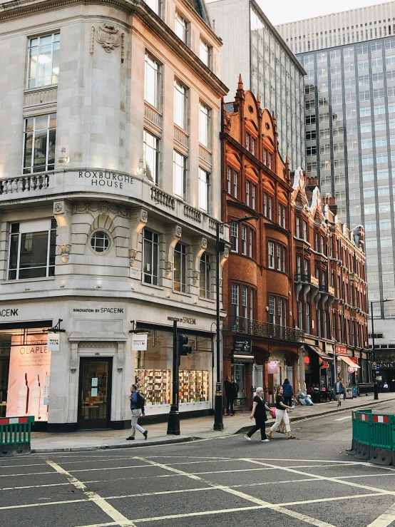 a group of people walking down a street next to tall buildings, london architecture, sephora, fan favorite, old shops