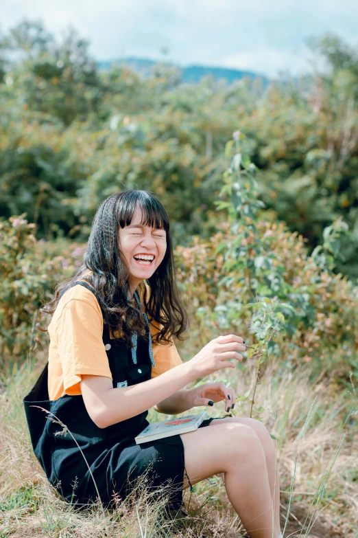 a woman sitting on top of a grass covered field, a picture, inspired by Kim Jeong-hui, pexels contest winner, mutahar laughing, kuntilanak on tree, student, with full bangs