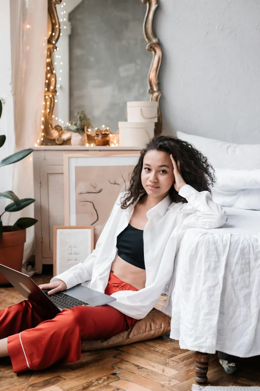 a woman sitting on the floor with a laptop, by Julia Pishtar, trending on pexels, happening, sitting on a bed, white jacket, ashteroth, asian features