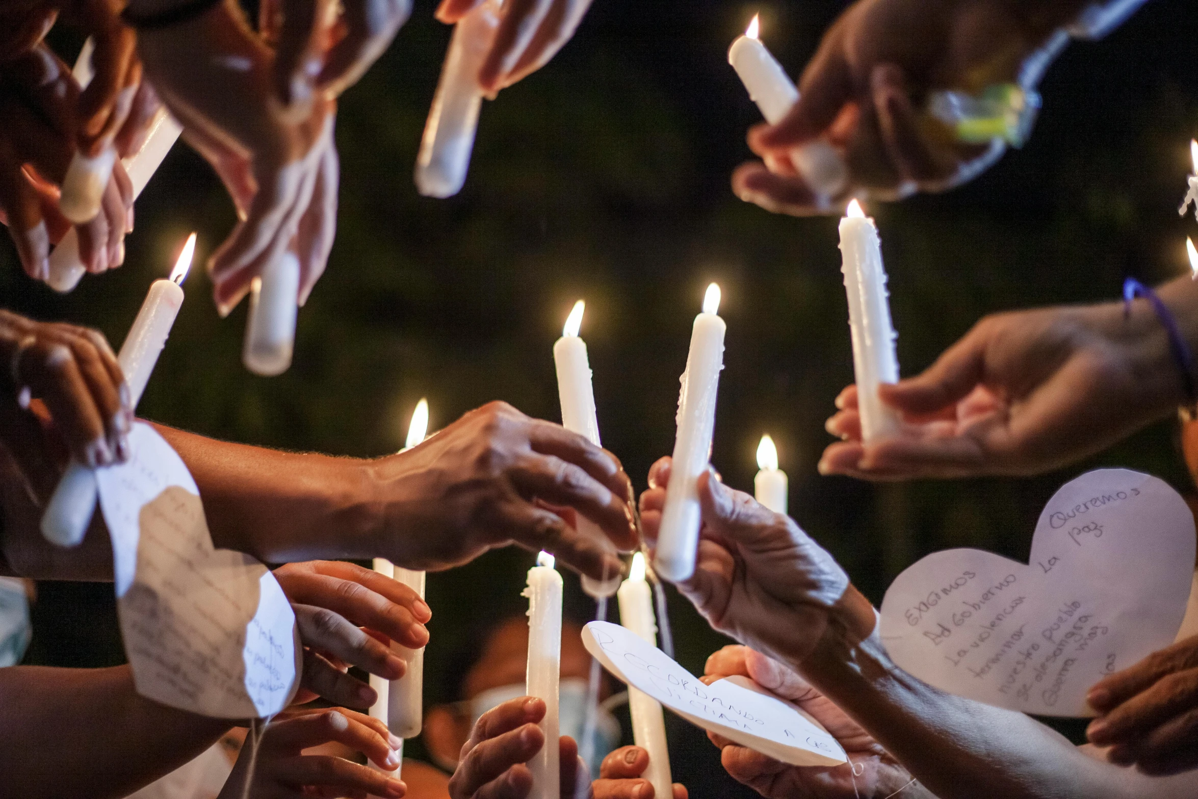 a group of people holding candles in a circle, white ribbon, instagram post, ap news, no watermarks