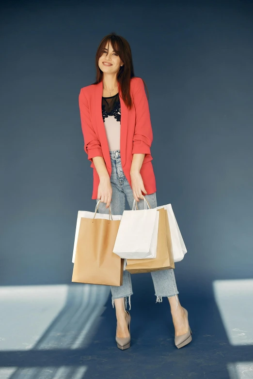 a woman holding shopping bags in her hands, a colorized photo, pexels contest winner, wearing a blazer, japanese collection product, jeans and t shirt, arper's bazaar